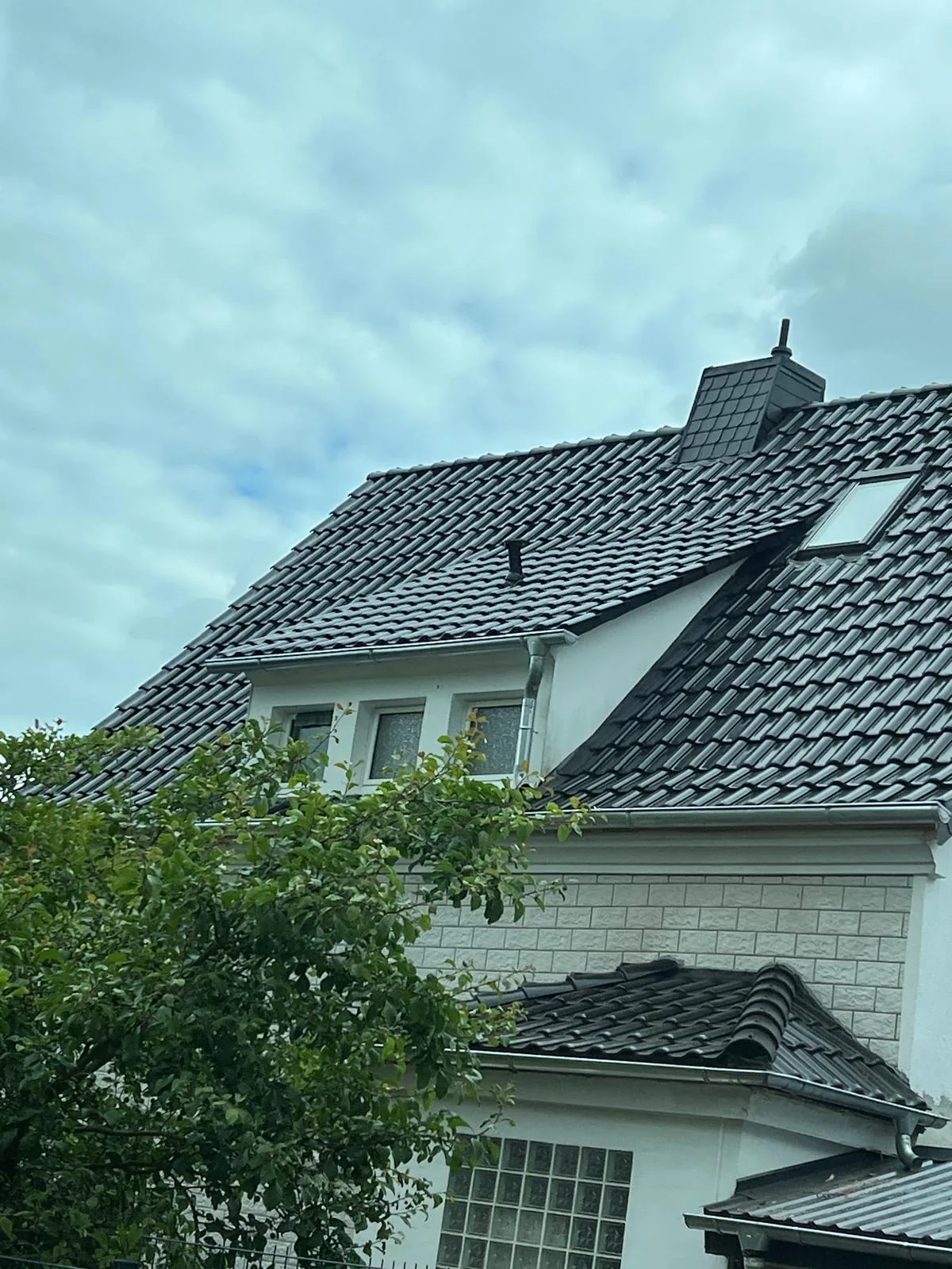 Fertiggestelltes dunkles Ziegeldach mit Gaube